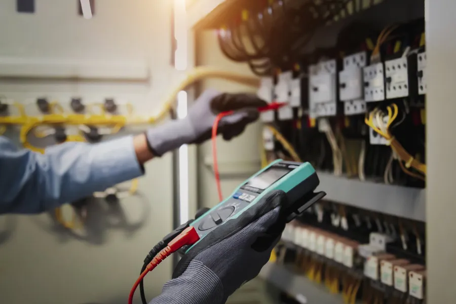 Elektriker prüft einen Verteiler mit dem Messgerät