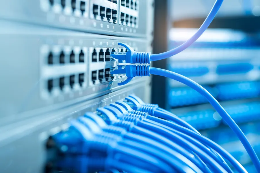 Blaue Netzwerkkabel an einem Switch im Serverschrank
